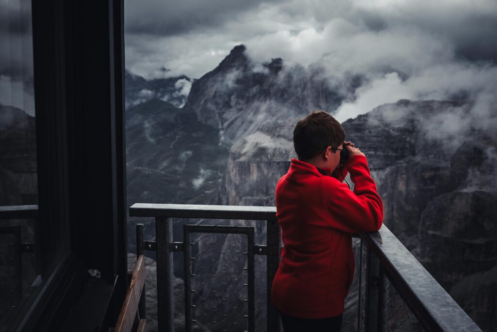 Child Observing Mountain Landscape with Binoculars