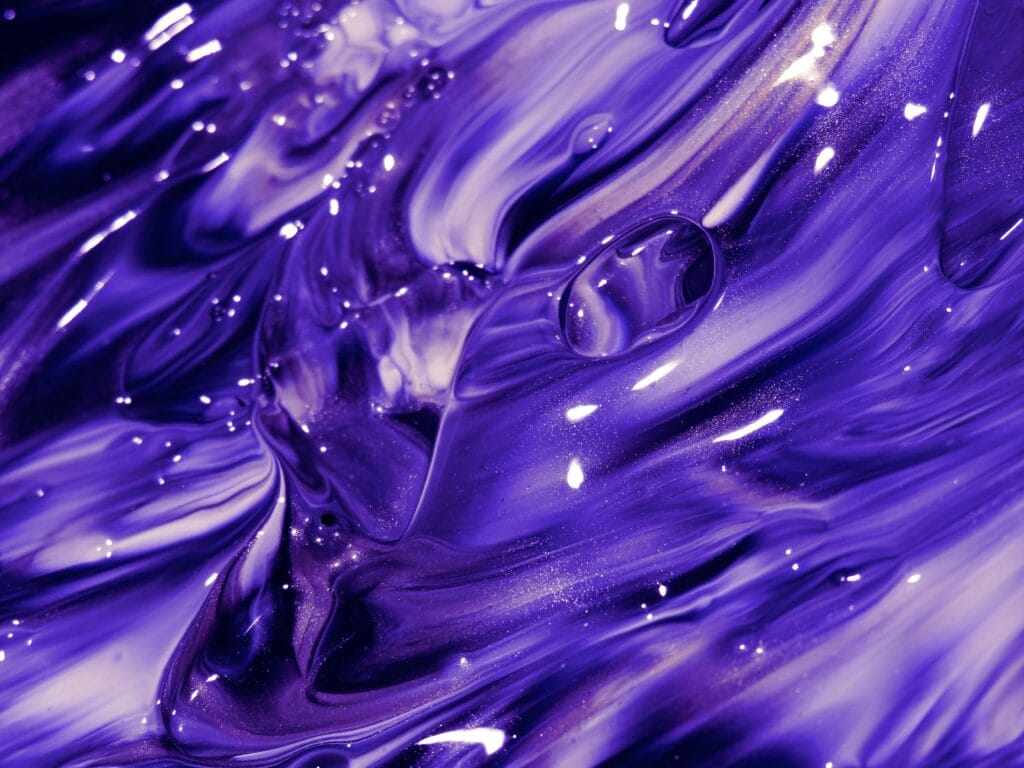Explore the mesmerizing swirls of vivid purple paint creating a captivating abstract texture.